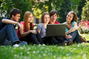 Group of university students using laptop outdoors